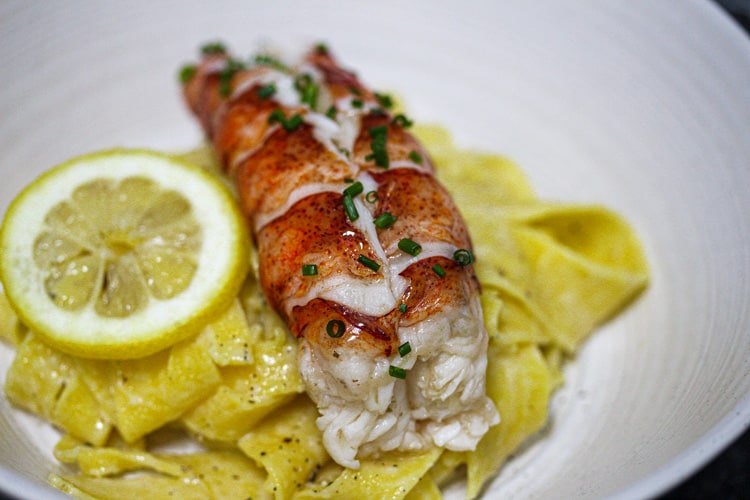 Sous Vide lobster tail on lemon pasta chives garnish
