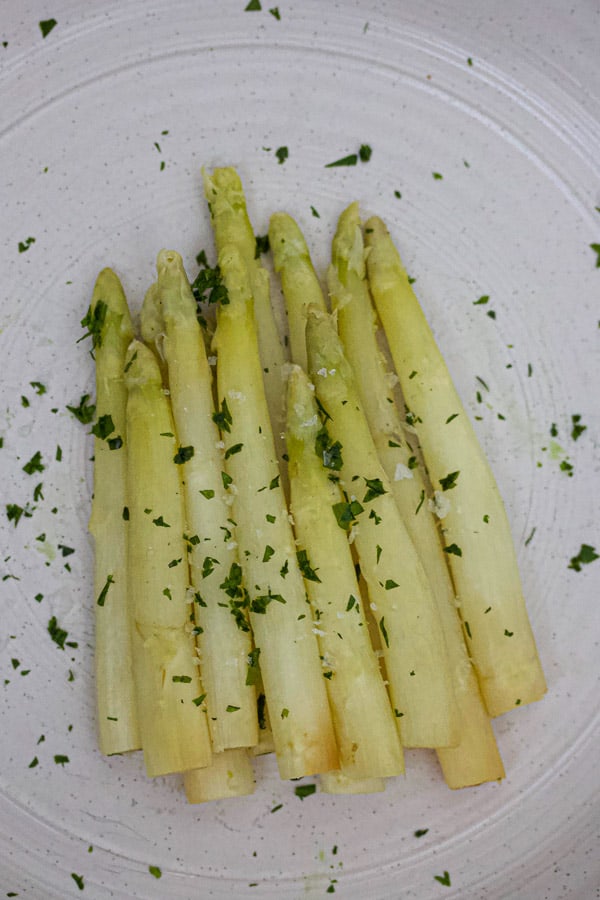 white asparagus with flake salt and parsley