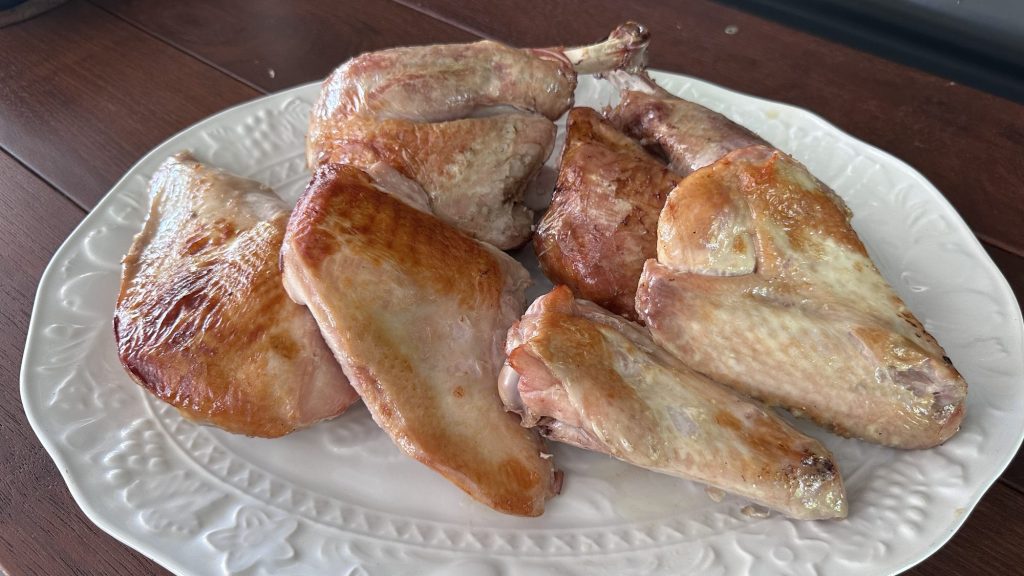 Two sous vide turkey legs and breasts, oven finished, on a white platter