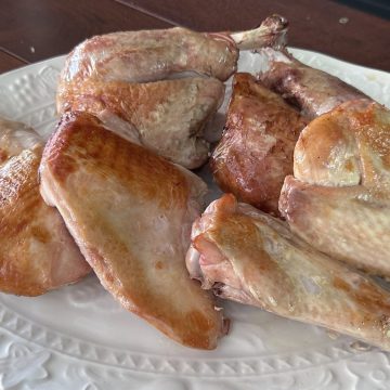 Two sous vide turkey legs and breasts, oven finished, on a white platter