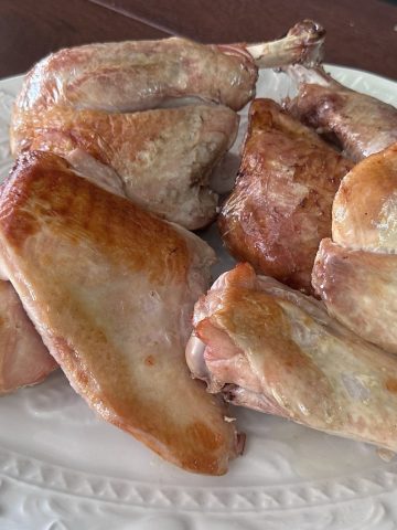 Two sous vide turkey legs and breasts, oven finished, on a white platter