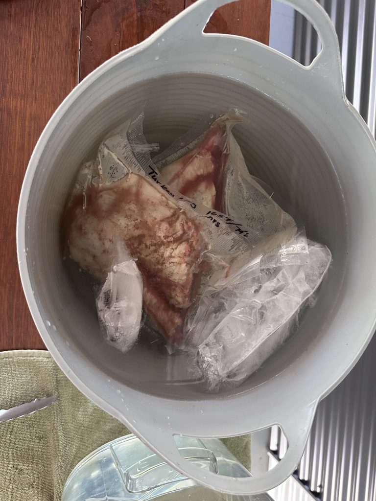 Cooked turkey leg in its sous vide bag chilling in an ice bath