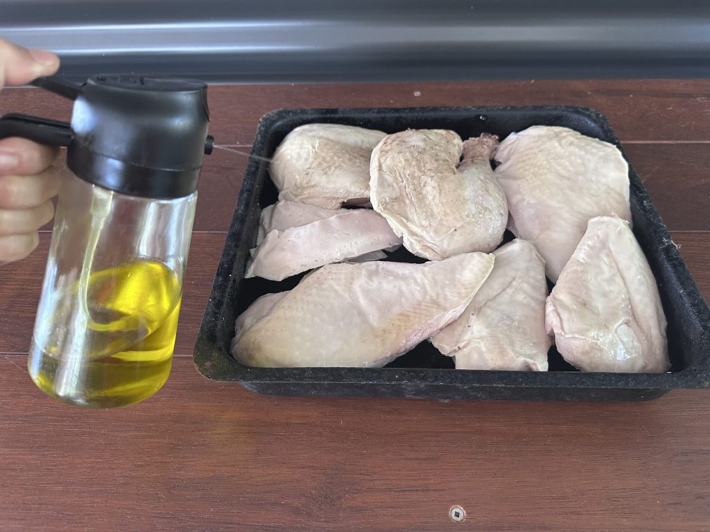 Spraying olive oil over sous vide turkey legs and breasts before roasting