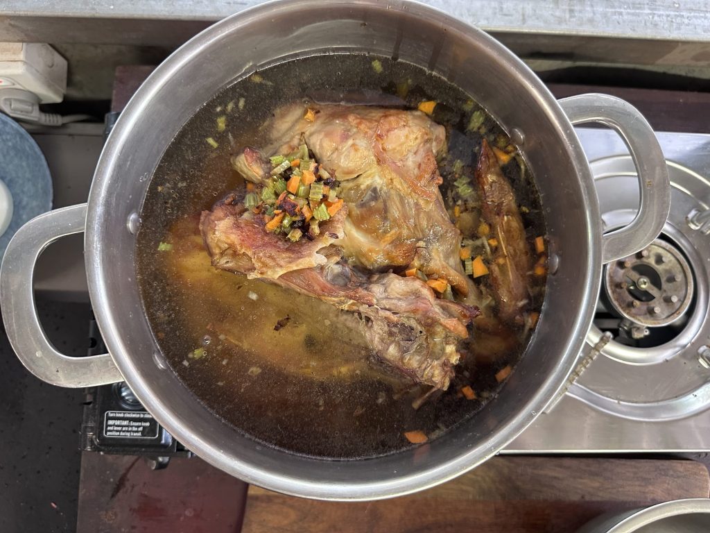 Roasted turkey bones and vegetables simmering in a stockpot
